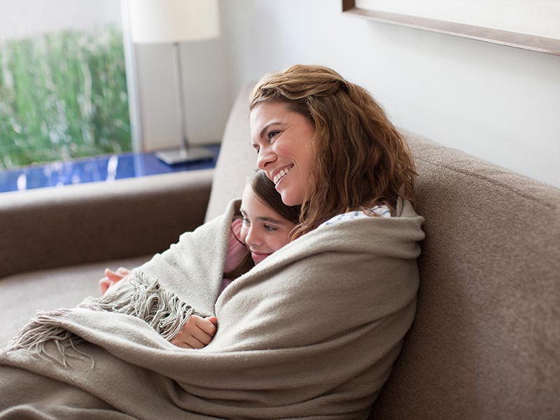 mother and daughter wrapped in blanket